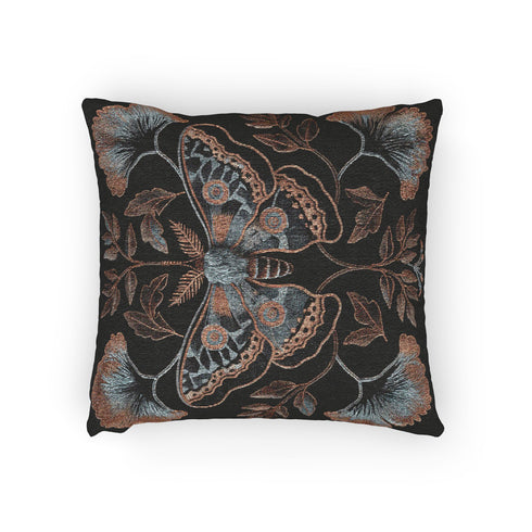 A square decorative pillow featuring an intricately detailed Luna moth in copper, terra cotta and slate blue colors on a black background. The moth is centered in a symmetrical arrangement with ginkgo-inspired leaves and botanical elements surrounding it.